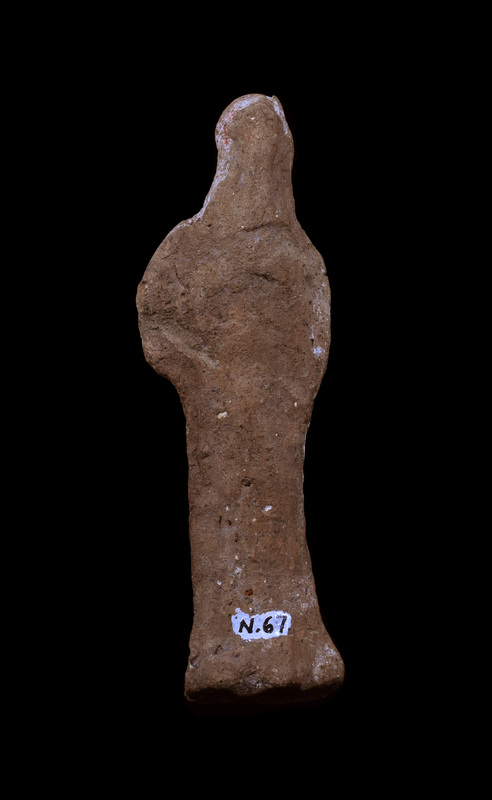 Mouldmade standing figure of indeterminate sex with arms crossed diagonally on upper body and legs articulated by pinched vertical ridges; face projecting forward with vertical ridge marking prominent nose; on flat base semi-circular at front.  Apparently coated on front with red paint over white slip.