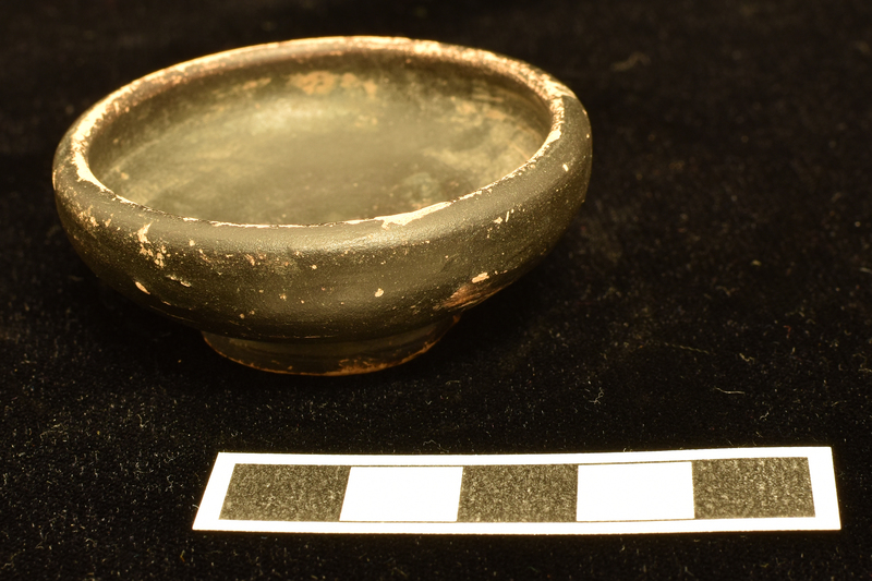 Convex-sided bowl w max D just below rim on ring base, deeply concave  on underside w central nipple.  Coated all over w dark paint.