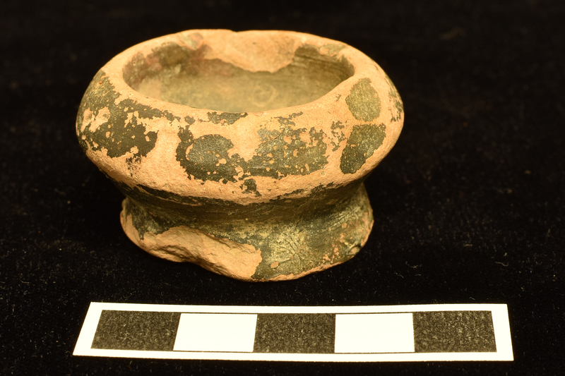 Thick-walled carinated bowl on low, broad pedestal base.  Thick plain rim.  Coated all over w black paint.