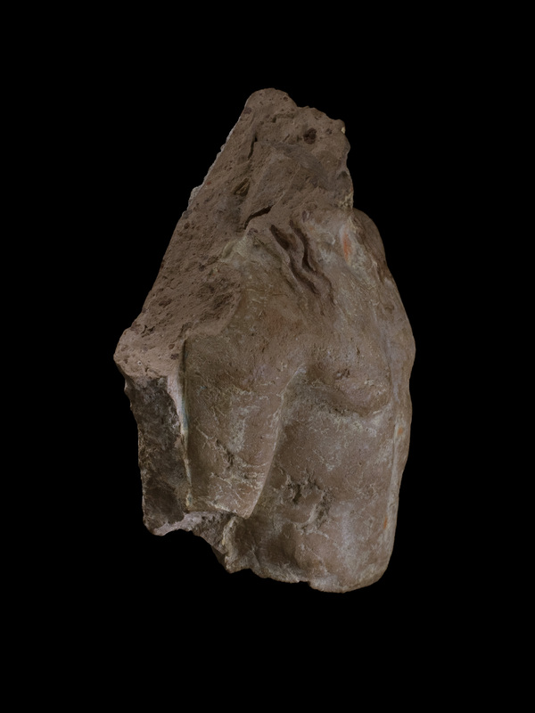 Slab w richly-modeled nude male torso, probably Apollo, w three tendrils of wavy hair falling over each shoulder, r arm held closer to body than l. Coated w white slip w hair painted red and background blue.