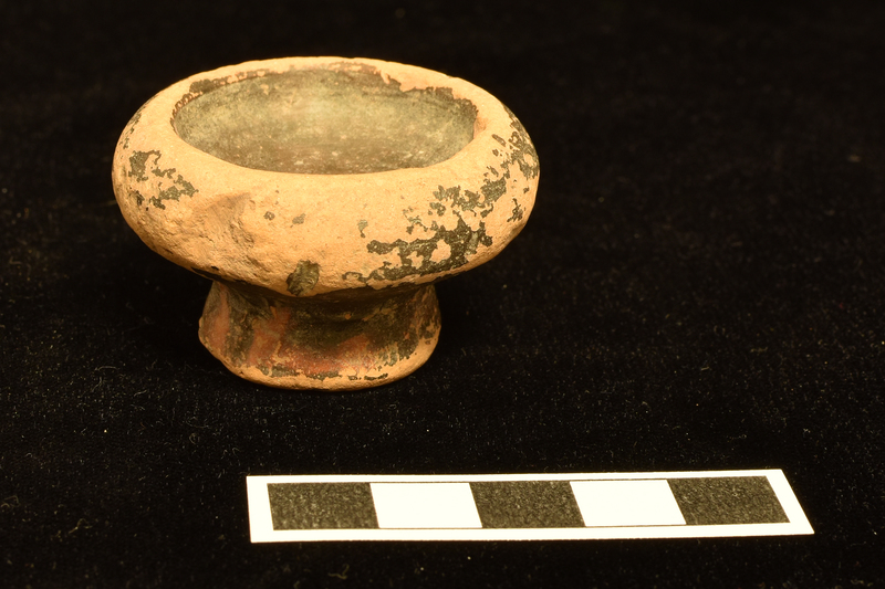 Small, but very thick-walled vessel with tall incurved rim; shallow bowl on comparatively high pedestal base.  Completely coated inside and out, including underside of base.