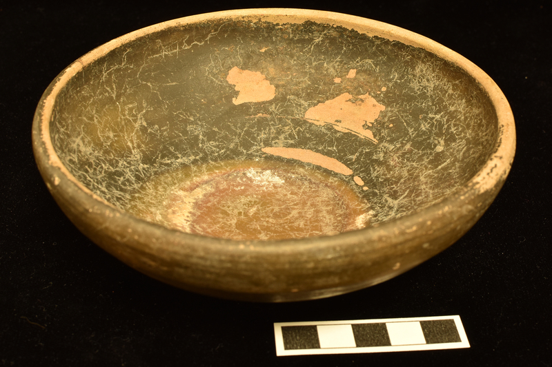 Bowl with low incurving rim on low ring base; prominent wheel marks on ext of bowl.  Coated inside and out except for patches on lower bowl and underside of ring and all of base within ring.