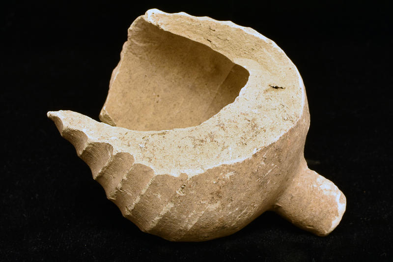 Fragment from lower body: piriform w h ribs fading toward lower body from which extends cylindrical finial, flat on bottom.