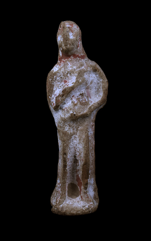 Mouldmade standing figure of indeterminate sex with arms crossed diagonally on upper body and legs articulated by pinched vertical ridges; face projecting forward with vertical ridge marking prominent nose; on flat base semi-circular at front.  Apparently coated on front with red paint over white slip.