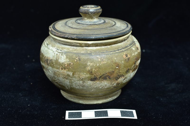 N.8a: Low convex-bodied pyxis w primary decoration on body  between narrow  stripes: heraldic sphinxes on either side of incised staff with two stars above , another below; at rear grazing deer and lion; blob rosettes in field;  figures and rosettes  decorated with incision; low flaring base decorated with dark stripe on bottom edge. N.8b: Lid, probably not belonging, fairly flat with conical handle, decorated with  narrow concentric stripes with top of handle solidly coated.