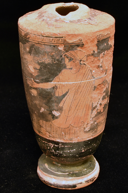 Fragmentary lekythos w main zone decorated with woman running right , looking left, with kalathos on ground before her with meander band above reserve stripe below: woman wearing chiton and himation and sakkos on head.  Lower body top of profile foot and exterior of base torus solidly coated.  Shoulder decoration probably radiating stripes but mostly worn off. stripes but mostly worn off.