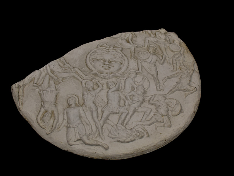 Cast of a fragmentary sculpture of a shield with relief decoration showing battle between Greeks and Amazons around a central gorgoneion. Original in British Museum, a Roman period reduced version of the shield of the Athena Parthenos by Pheidias. 