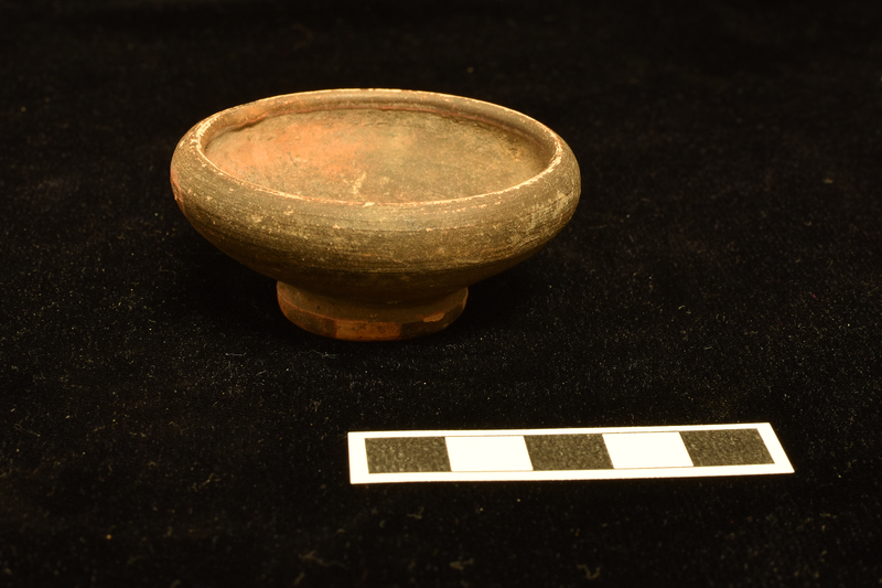 Bowl with rather high incurving rim on ring base with deep central concavity.  Bowl completely coated inside and out; base exterior and interior incompletely coated.