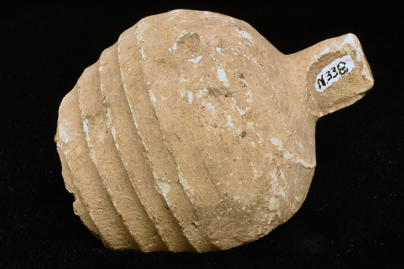 Fragment from lower body: piriform w h ribs fading toward lower body from which extends cylindrical finial, flat on bottom.