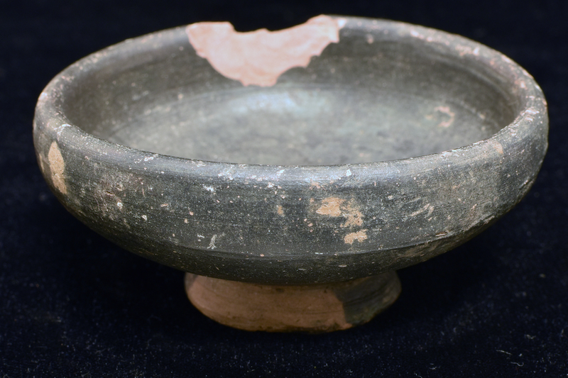 Convex-sided bowl rising ca vertically in upper portion to thick rim; ring base w swirl in center of underside.  Coated all over except for portion of  ext and underside of base w dark paint.