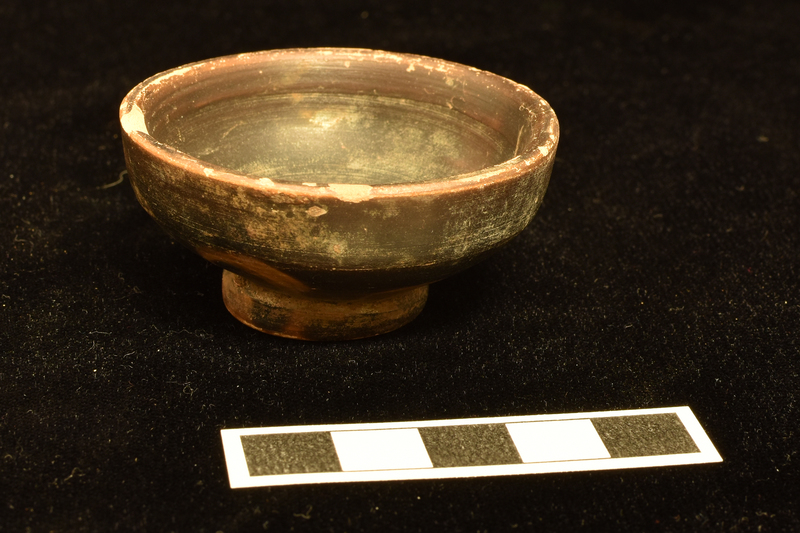 Bowl with tall vertical rim on ring base; coated inside and out including most of underside of base.