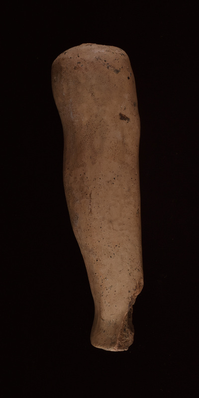 R leg & foot. Leg from above small knee w thigh modeled on inside & outside, tapering to ankle where both inner & outer bone articulated; above knee leg spreads to well rounded articulation w convex top surface perforated by small vent hole.  Flat under surface of foot which unmodulated as far as preserved.