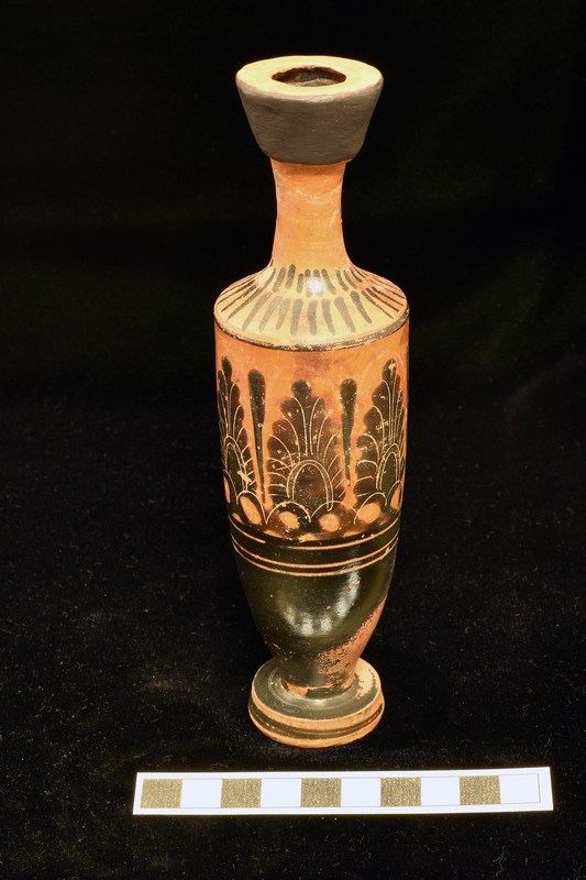 Trumpet- mouthed lekythos with main zone decorated with three upright palmettes opposite handle with slender leaf between and to right of palmette at right; below broad stripe flanked by two narrow stripes lower body totally coated, stripe in center of exterior of foot; single stripe at juncture of body and shoulder above which lower band of longer stripes upper band of vertical stripes and back of handle solidly coated.